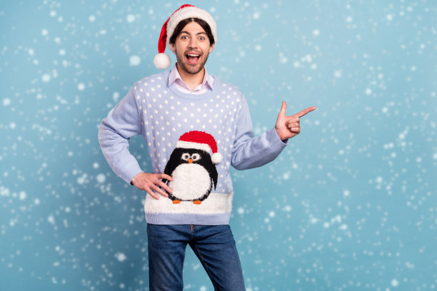 年轻快乐积极的男人的照片好心情点手指空的空间圣诞微笑孤立在蓝色的背景图片下载