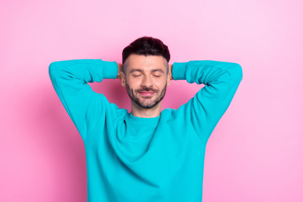 睡觉的年轻学生的照片，深色头发的男人在大学课程休息后，无忧无虑地幻想着未来，孤立在粉红色的背景上图片下载