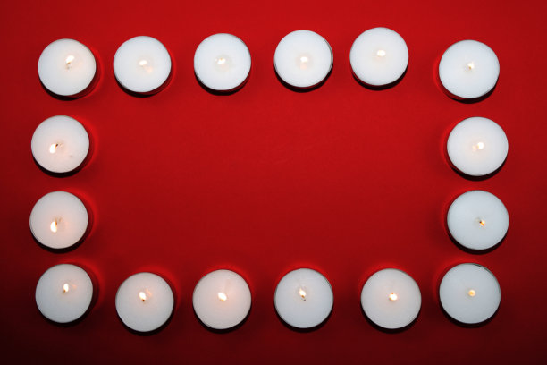 红色背景上的白色蜡烛。图片下载