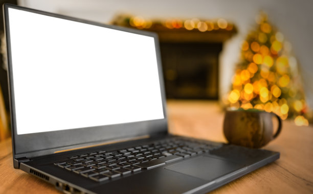 笔记本电脑与一个空白的白色屏幕和圣诞树的背景图片下载