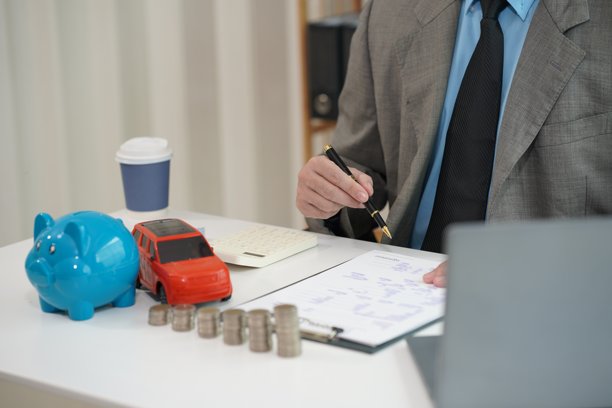 保险概念，汽车税，销售利润，一堆硬币和商人用电脑和文件工作特写图片图片下载