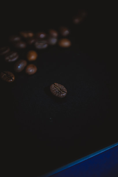 这张照片是大量烘焙咖啡豆的特写，营造出质感和香气。豆子从浅棕色到深棕色不等，强调多样性图片下载