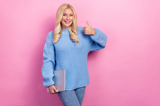 照片正面可爱的女士穿着蓝色时尚的衣服大拇指质量现代小工具空的空间孤立在粉红色的背景图片下载