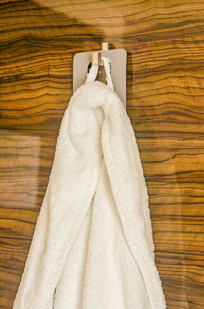 白色浴袍挂在酒店的木墙上图片下载