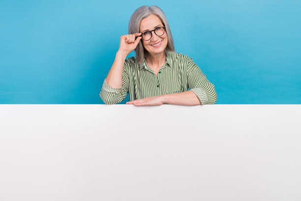 照片积极乐观聪明的高级商务女士条纹衬衫触摸规格附近的空白空间横幅销售孤立的蓝色背景图片下载