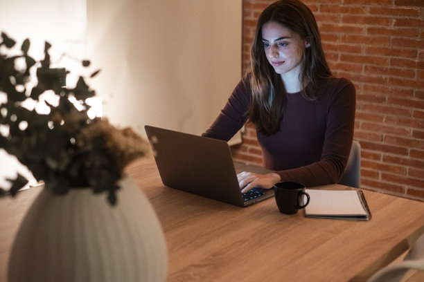 年轻的女商人晚上在家里的办公室里工作，用笔记本电脑做生意赚钱。这张照片说明了远程办公和现代女性管理任务的聪明工作图片下载