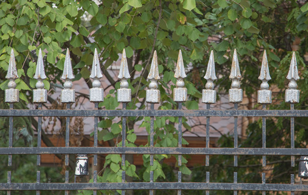 一张铁栅栏的照片，上面有对称的尖钉，每个尖钉都集中在顶部和底部，上面画着白色的细节图片下载