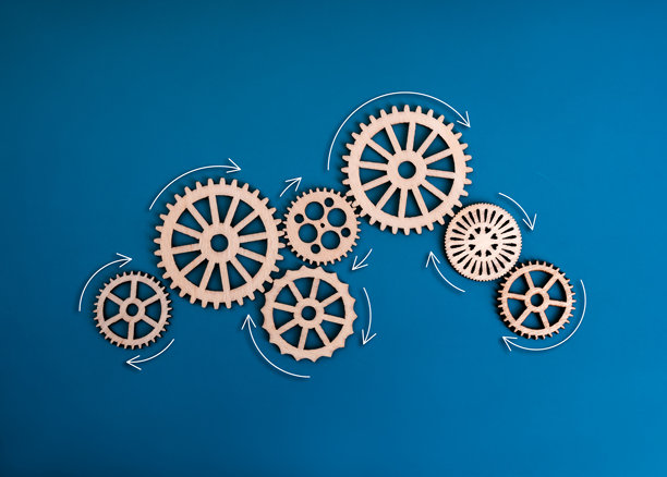 团队合作，业务流程系统，战略和管理理念。许多图案的木制齿轮和齿轮的工作过程与流动的箭头孤立在蓝色背景，极简主义。图片下载