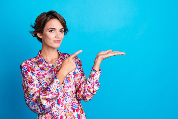 照片中漂亮可爱的女孩穿着时尚的衣服，手臂抱着新奇的东西，推荐购买产品，空白的空间孤立在蓝色的背景上图片下载