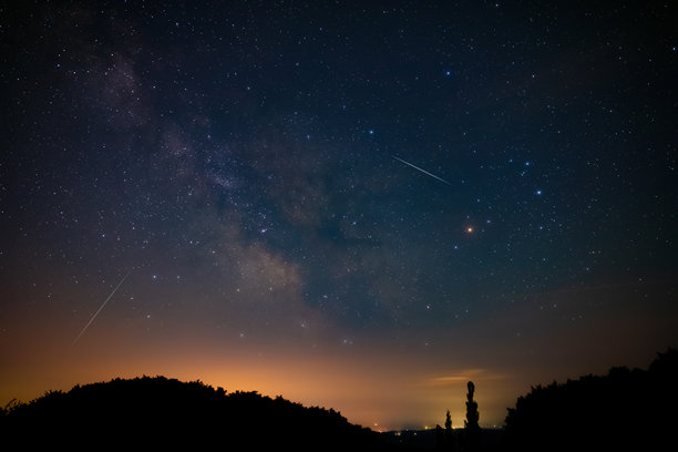 银河系的星星，流星雨的轨迹和乡村的剪影。图片下载