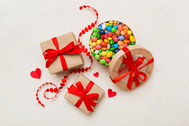 情人节作文:甜甜的糖果，带蝴蝶结和红心毡礼盒，照片模板，背景。带复制空间的俯视图图片下载