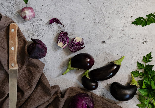 新鲜的迷你茄子在一个木制盘子在一个白色的木制背景。蔬菜。图片下载