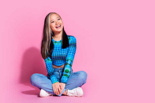迷人的积极的女人穿蓝色上衣的全长照片微笑着看空空间孤立的粉红色背景图片下载