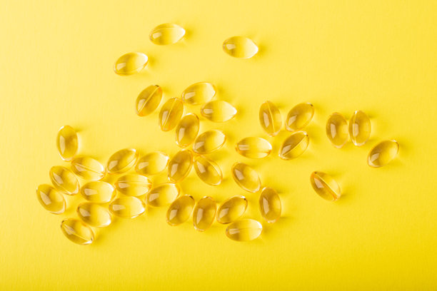欧米加- 3鱼油排在第一位。黄色背景的软胶囊维他命，鱼肝油。保健的概念，补充剂，维生素D，治疗。复制空间，平面，横幅。高质量照片图片下载