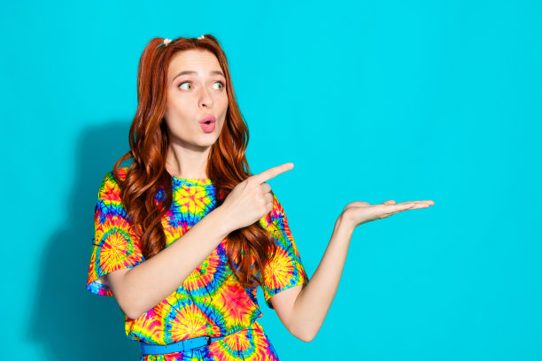 照片肖像的迷人的年轻女子点hold看惊奇的空白穿着彩色的衣服孤立在青色的背景图片下载