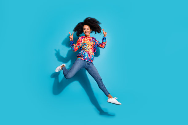 完整的照片可爱的年轻女士跑步秀v标志穿着时尚的彩色服装孤立的蓝色背景图片下载