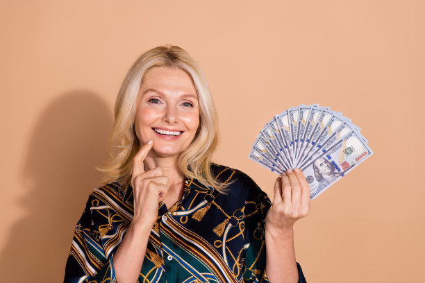 照片肖像的高级成功持有很多钱摸脸颊购物狂希望买东西孤立的米色背景图片下载