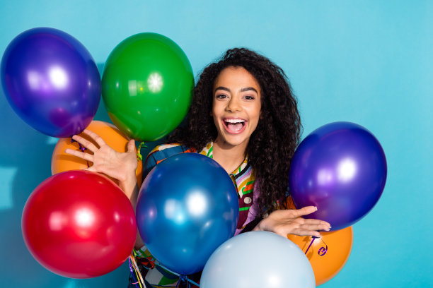 照片开朗积极可爱的女孩穿着时髦的衣服空气氦气球节日活动孤立的蓝色背景图片下载