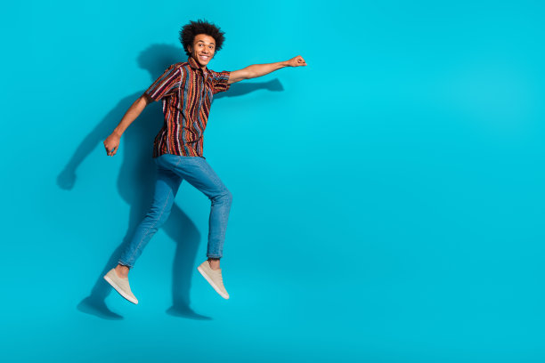 漂亮的年轻人的全尺寸照片跳跃跑空空间穿衬衫孤立的蓝绿色背景图片下载