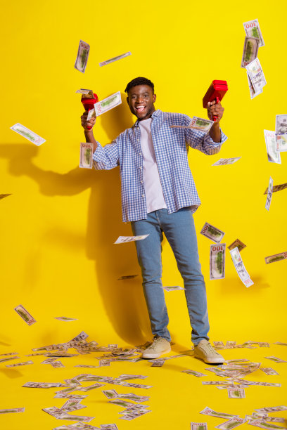 照片年轻英俊的美国人穿着格子衬衫拍摄钱美元机器钞票孤立在黄色背景图片下载