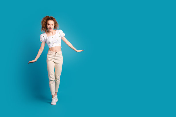可爱的年轻女士的全身照片保持平衡惊讶钢索穿着时尚的白色服装孤立的蓝色背景图片下载