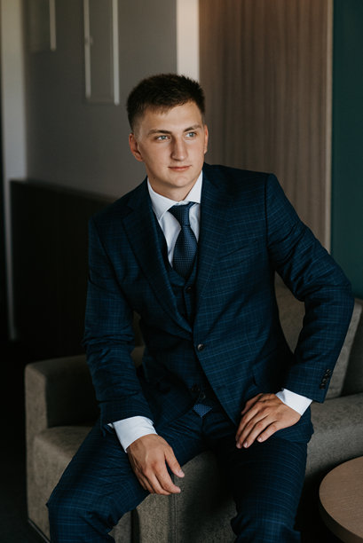 婚礼当天新郎身穿蓝色三件套西装打着领带的照片图片下载