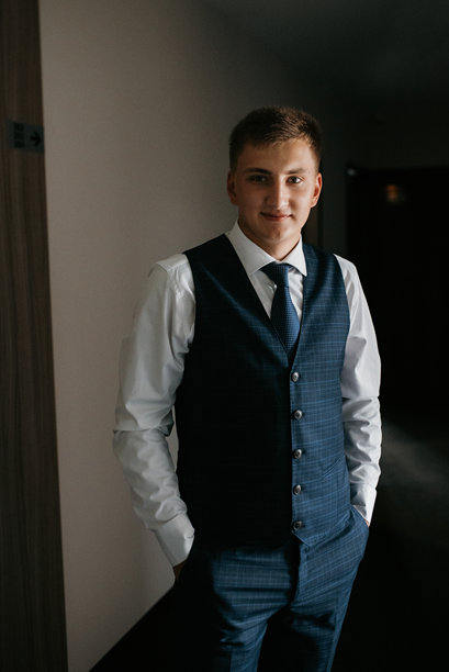 婚礼当天新郎身穿蓝色三件套西装打着领带的照片图片下载