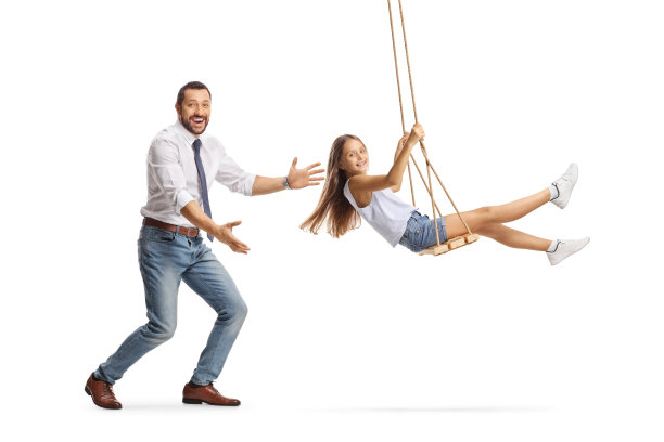 父亲推着女儿荡秋千，面带微笑的全身侧面照图片下载