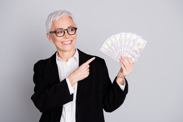 照片中有魅力的成熟的女性职业ceo手持点看钱范穿着正装，眼镜孤立在灰色背景上图片下载