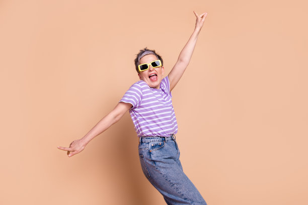 照片中，迷人的疯狂高级女子穿着条纹时尚服装，孤立在米色背景上图片下载