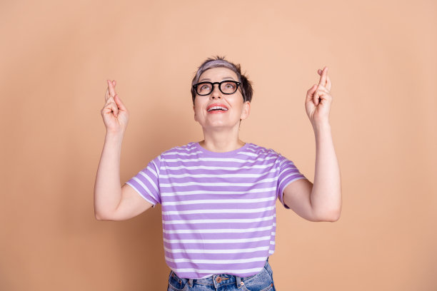 照片中有趣可爱的高级女子穿着条纹时尚的衣服，空白空间孤立在米色背景上图片下载