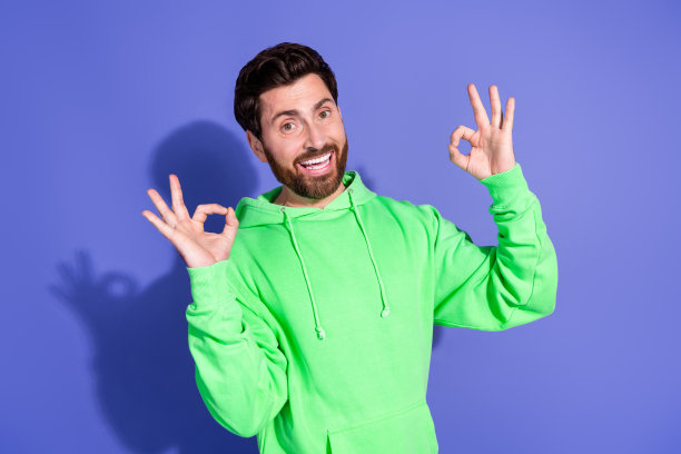 照片肖像的英俊成熟的年龄神祈祷男子穿着绿色连帽衫手掌在一起恳求孤立的紫罗兰色背景图片下载