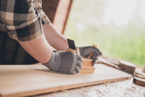 木工的裁剪照片，木工家伙与木板应用工具在车库室内工作图片下载