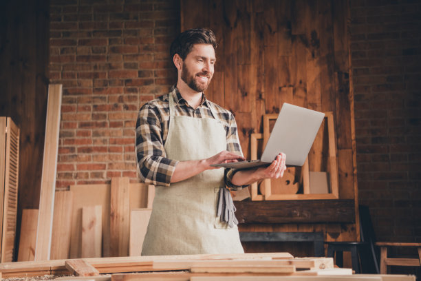 快乐微笑的家伙在车库室内使用上网本的照片图片下载