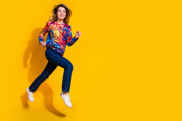 年轻快乐的金发甜美女孩的照片肖像，匆忙奔跑，快速跳跃，开始销售季节孤立的黄色背景图片下载