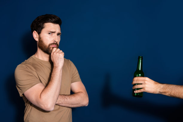 成熟年龄的照片肖像深色胡子的滑稽男子身穿米色t恤怀疑选择啤酒孤立在深蓝色的背景图片下载