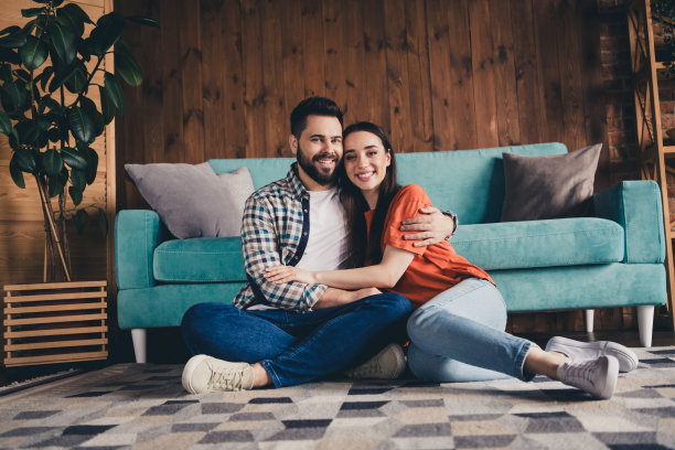 欢快可爱的年轻夫妇的全身照片坐在地板上拥抱享受周末玩得开心买新公寓在室内在家里图片下载