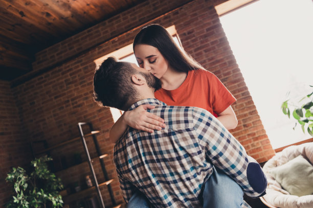 幸福的年轻夫妇的照片丈夫抱着妻子亲吻搬到新的地方享受住在一起玩新公寓房间灯房子公寓室内图片下载