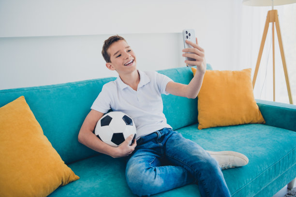 照片可爱的男生智能手机自拍足球穿t恤现代室内公寓室内图片下载