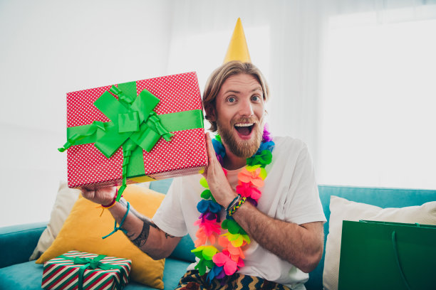 照片迷人的年轻男性兴奋庆祝节日礼盒穿着睡衣舒适的日光家室内客厅图片下载
