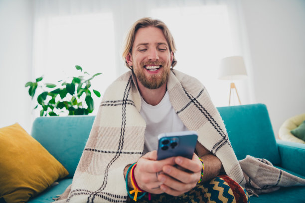 迷人的年轻男性的照片盖毯子抱装置坐沙发穿睡衣舒适的日光家室内客厅图片下载