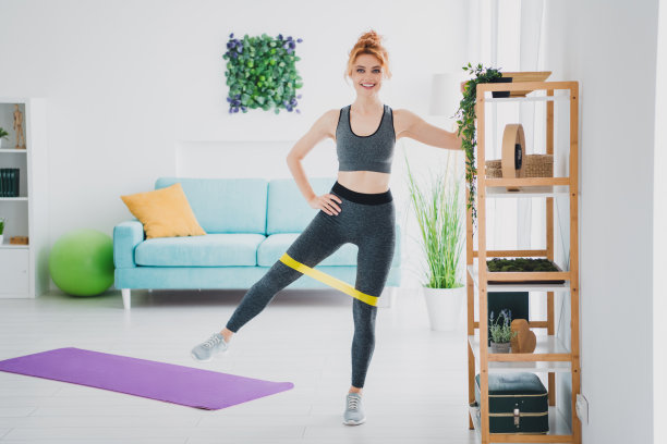 照片的运动有吸引力的强壮的女人穿着运动服做体育锻炼在家里客厅日光室内图片下载