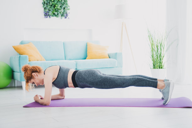 漂亮的运动年轻女士平板支撑健身垫家庭体育馆室内练习的全尺寸照片图片下载