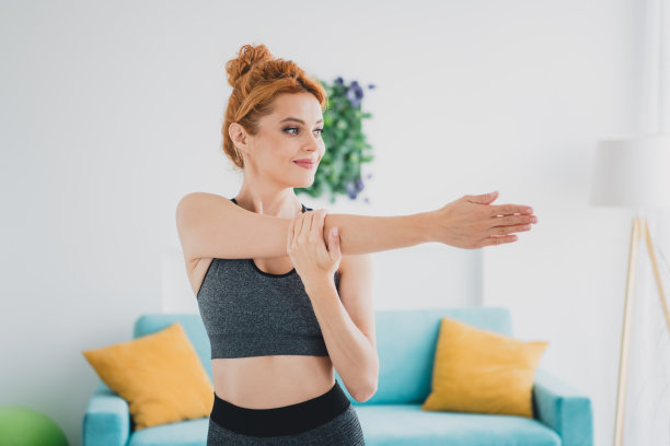 照片中的运动活跃可爱的女人穿着运动服做体育锻炼客厅日光室内图片下载