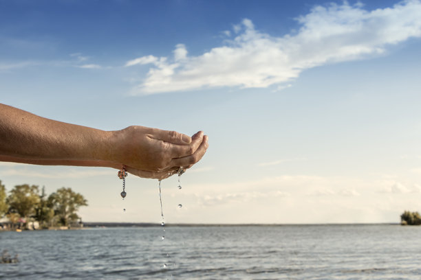 人的手从湖里取淡水。图片下载