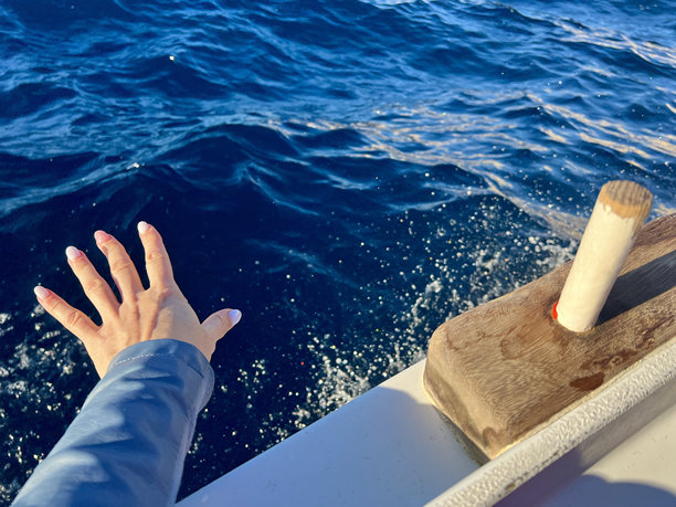 人类用手从小船上看到的大海背景上的波浪。图片下载