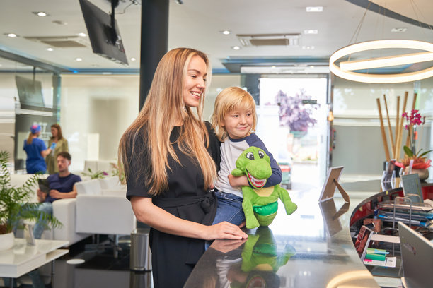 在牙医的接待处，母亲把孩子抱在怀里图片下载