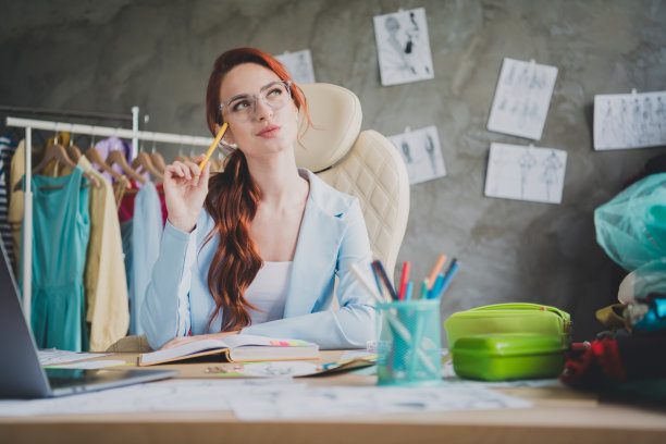 女孩店员的照片，坐在桌子上写文案，在商店办公室工作室思考图片下载