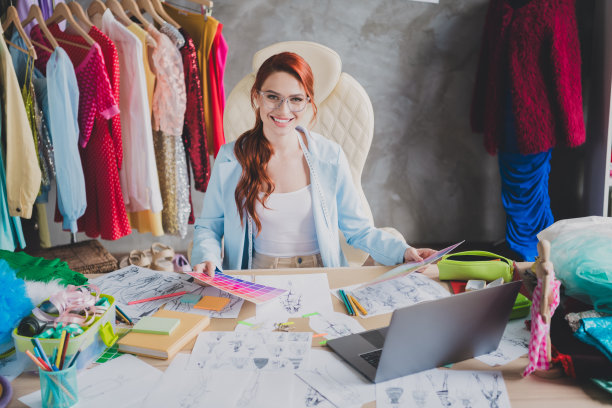 专业的女孩设计师坐在桌子上持有调色板样品在工作室室内工作场所的照片图片下载