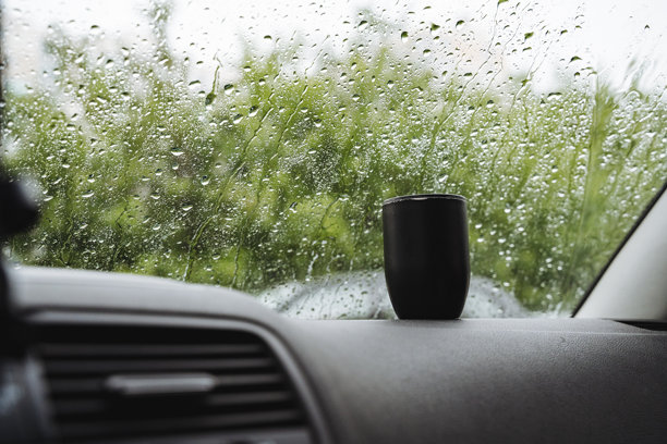 这张照片拍摄的是落在汽车挡风玻璃上的雨滴，描绘了开车时阴冷的天气，给人一种忧郁的基调。它描绘了一个下雨天开车的情景图片下载